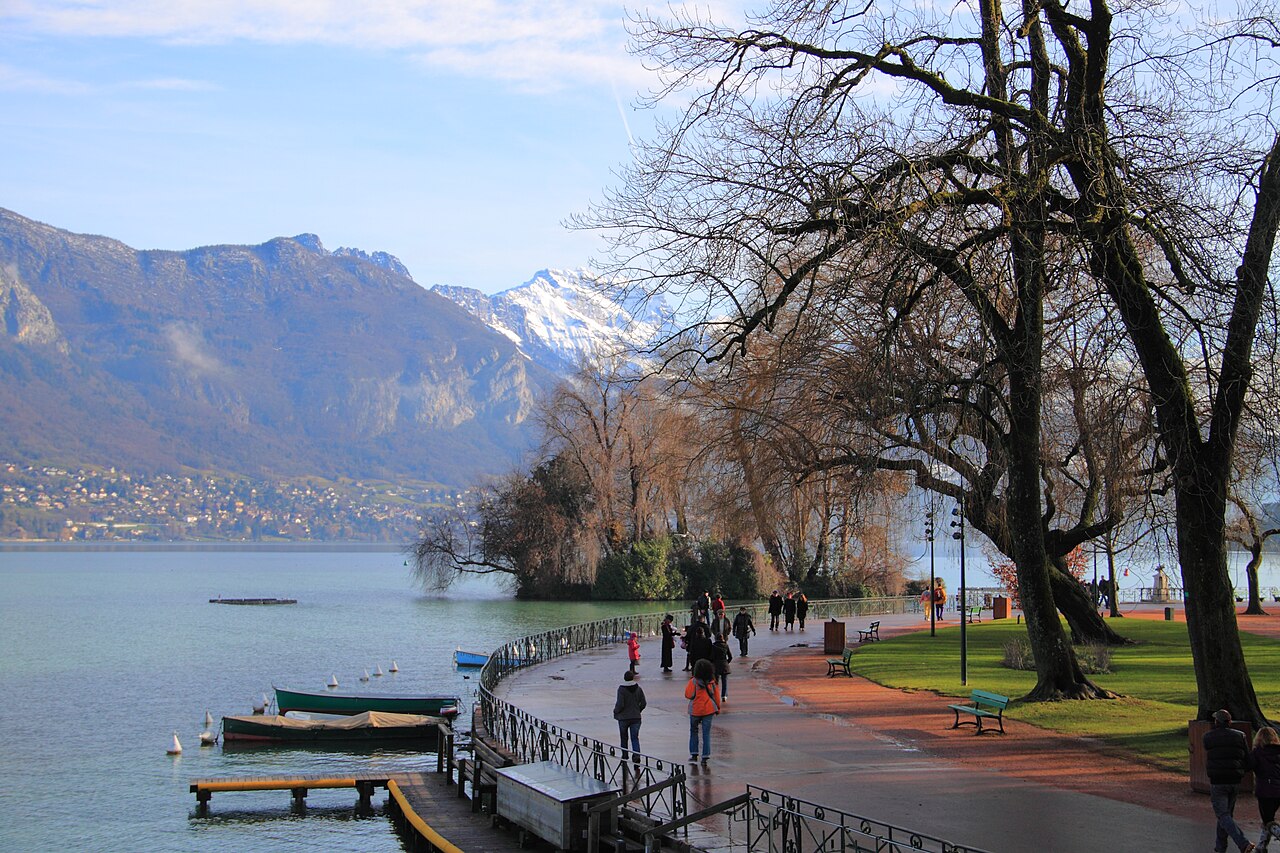 Wandelpad en bootjes aan het Meer van Annecy met bergen op de achtergrond