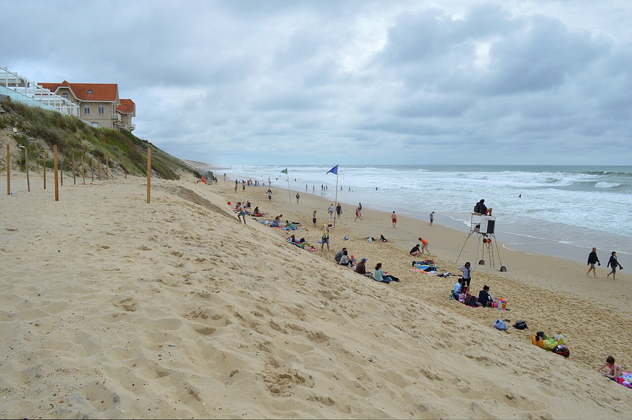 Zandstrand met bezoekers en golven aan de Atlantische kust bij Biscarrosse